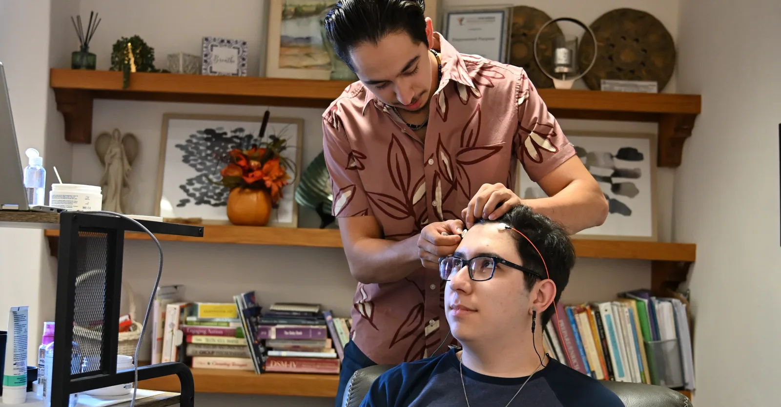 A practitioner placing LENS Neurofeedback sensors on a client at Empowered Purpose