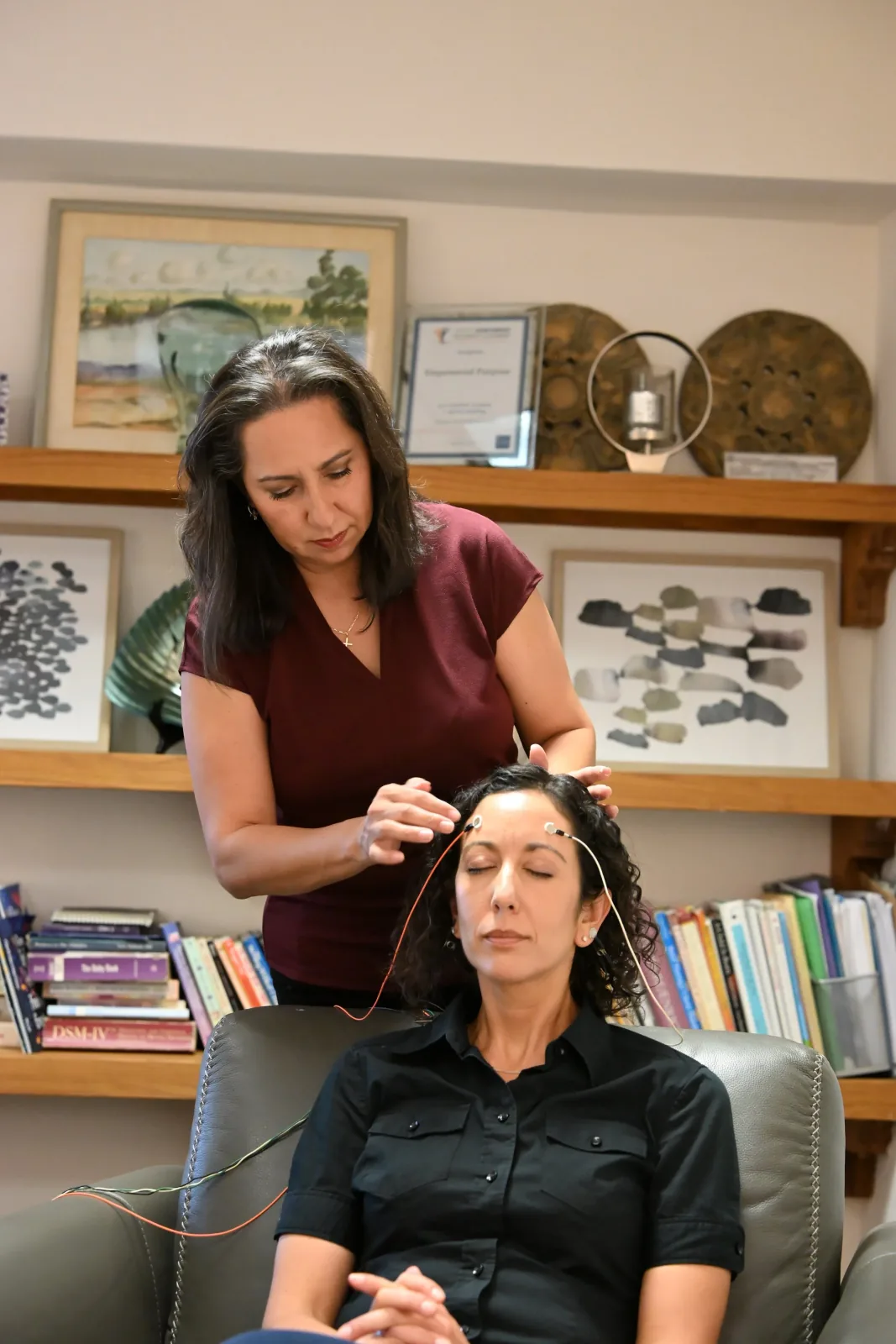 Diana Mueller placing LENS Neurofeedback sensors on a client during a session at Empowered Purpose